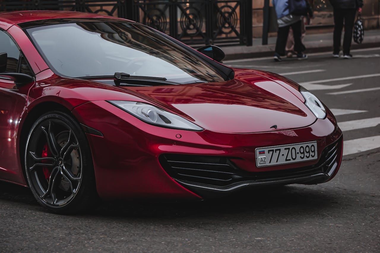 A luxurious red sports car parked on a city street, showcasing its sleek design and modern aesthetics.