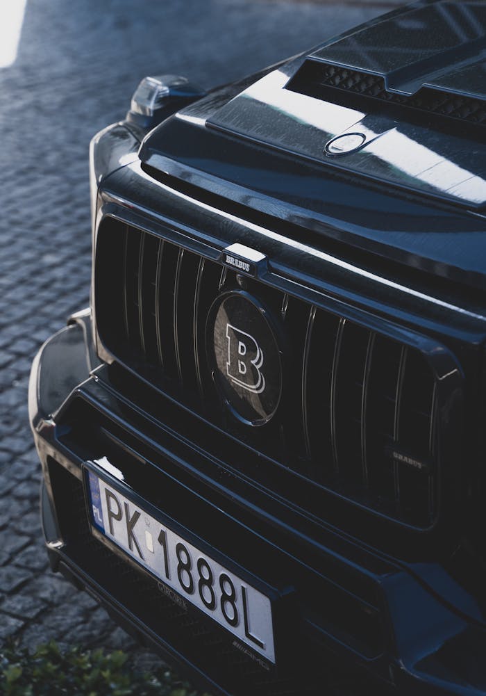 Detailed view of a luxury car's front grill and license plate in Poznań, Poland.